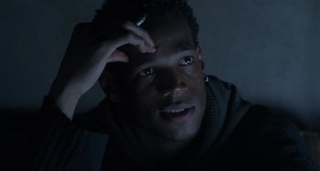 Movie still from “Requiem for a Dream” (2000), directed by Darren Aronofsky – A young man is sitting in the dark with a cigarette in his hand; Close Up shot, Over the shoulder angle