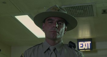 Movie still from “Requiem for a Dream” (2000), directed by Darren Aronofsky – A man in a hat and uniform is looking at the camera; Close Up shot, Low angle