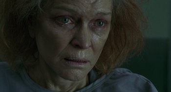 Movie still from “Requiem for a Dream” (2000), directed by Darren Aronofsky – An older woman with red hair and green eyes looking at the camera; Close Up shot, Low angle