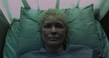 Movie still from “Requiem for a Dream” (2000), directed by Darren Aronofsky – An older woman laying in a bed looking at the camera; Close Up shot, Overhead angle