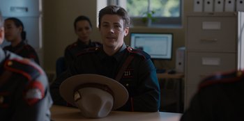 Movie still from “Rescued by Ruby” (2022), directed by Katt Shea – A man in uniform sitting in front of a computer; Medium shot, Over the shoulder angle
