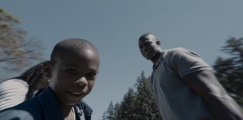 Movie still from “Rescued by Ruby” (2022), directed by Katt Shea – Two young men standing next to each other in a wooded area; Close Up shot, Low angle