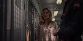 Movie still from “Rescued by Ruby” (2022), directed by Katt Shea – A woman standing in front of a metal fence; Medium shot, Over the shoulder angle