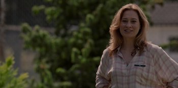 Movie still from “Rescued by Ruby” (2022), directed by Katt Shea – A woman standing in front of trees smiling for the camera; Close Up shot, Over the shoulder angle