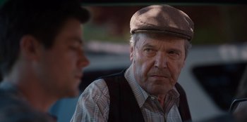Movie still from “Rescued by Ruby” (2022), directed by Katt Shea – An older man wearing a hat and a plaid vest; Close Up shot, Over the shoulder angle