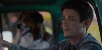 Movie still from “Rescued by Ruby” (2022), directed by Katt Shea – A man sitting in the driver's seat of a car with a dog; Close Up shot, Over the shoulder angle