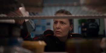 Movie still from “Rescued by Ruby” (2022), directed by Katt Shea – A woman wearing a uniform looking out a window; Close Up shot, Low angle