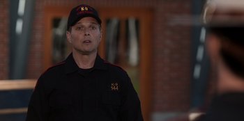 Movie still from “Rescued by Ruby” (2022), directed by Katt Shea – A man in a black uniform wearing a hat; Close Up shot, Over the shoulder angle