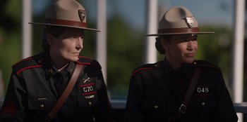 Movie still from “Rescued by Ruby” (2022), directed by Katt Shea – A couple of women in uniform standing next to each other; Medium shot, Over the shoulder angle