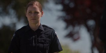 Movie still from “Rescued by Ruby” (2022), directed by Katt Shea – A woman in a police uniform is looking at the camera; Close Up shot, Over the shoulder angle