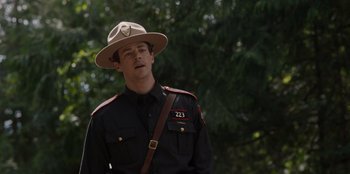 Movie still from “Rescued by Ruby” (2022), directed by Katt Shea – A man wearing a hat and a uniform; Close Up shot, Over the shoulder angle