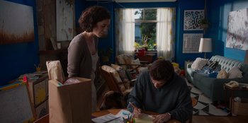 Movie still from “Rescued by Ruby” (2022), directed by Katt Shea – A woman standing next to a man writing on a piece of paper; Medium shot, Over the shoulder angle