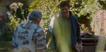 Movie still from “Rescued by Ruby” (2022), directed by Katt Shea – A man standing next to another man in a park; Medium shot, Over the shoulder angle