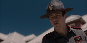 Movie still from “Rescued by Ruby” (2022), directed by Katt Shea – A man in a uniform is wearing a hat; Close Up shot, Over the shoulder angle