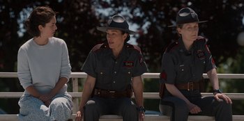 Movie still from “Rescued by Ruby” (2022), directed by Katt Shea – A couple of women sitting on top of a wooden bench; Medium shot, Over the shoulder angle
