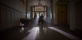 Movie still from “Rescued by Ruby” (2022), directed by Katt Shea – Two people are standing in a hallway with a dog; Extreme Wide shot, Low angle
