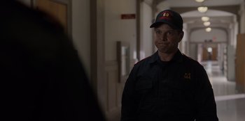 Movie still from “Rescued by Ruby” (2022), directed by Katt Shea – A man wearing a hat standing next to a wall; Close Up shot, Over the shoulder angle