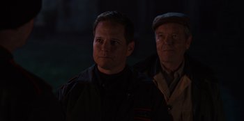 Movie still from “Rescued by Ruby” (2022), directed by Katt Shea – Two men standing in the dark looking at the camera; Close Up shot, Over the shoulder angle