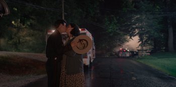 Movie still from “Rescued by Ruby” (2022), directed by Katt Shea – A man and a woman kissing on the side of the street; Wide shot, Low angle