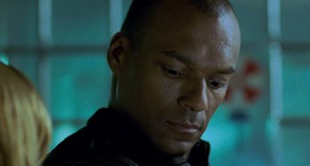 Movie still from “Resident Evil” (2002), directed by Paul W.S. Anderson – A man's face in a dark room; Close Up shot, Low angle