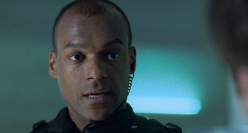 Movie still from “Resident Evil” (2002), directed by Paul W.S. Anderson – A person wearing a black jacket; Close Up shot, Low angle