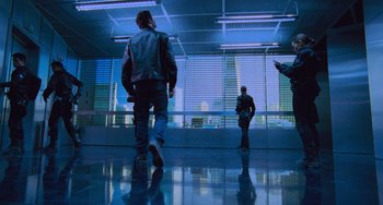 Movie still from “Resident Evil” (2002), directed by Paul W.S. Anderson – A group of people standing in front of a large window; Wide shot, Low angle