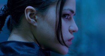 Movie still from “Resident Evil” (2002), directed by Paul W.S. Anderson – A woman's face in a dark room; Close Up shot, Low angle