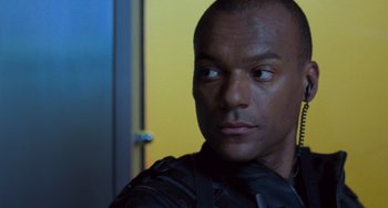 Movie still from “Resident Evil” (2002), directed by Paul W.S. Anderson – A person wearing a black jacket; Close Up shot, Low angle