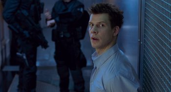 Movie still from “Resident Evil” (2002), directed by Paul W.S. Anderson – A man in a blue dress shirt is looking to his left; Close Up shot, Over the shoulder angle
