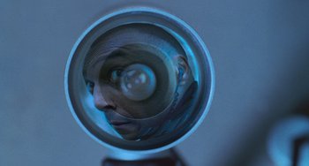 Movie still from “Resident Evil” (2002), directed by Paul W.S. Anderson – A man's reflection in a mirror of a person's face; Extreme Close Up shot, Overhead angle