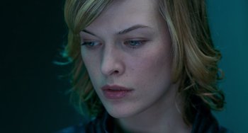 Movie still from “Resident Evil” (2002), directed by Paul W.S. Anderson – A woman's face in a dark room; Close Up shot, Low angle