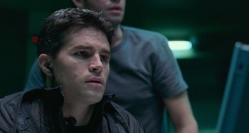 Movie still from “Resident Evil” (2002), directed by Paul W.S. Anderson – A man in a black jacket and a man in a gray shirt; Close Up shot, Over the shoulder angle