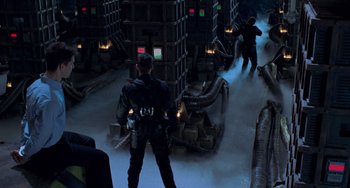 Movie still from “Resident Evil” (2002), directed by Paul W.S. Anderson – A man in a black suit standing next to another man in a black suit; Wide shot, High angle