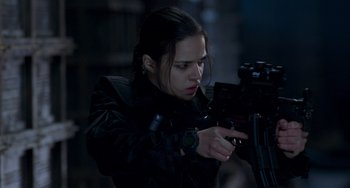 Movie still from “Resident Evil” (2002), directed by Paul W.S. Anderson – A woman in a black leather jacket holding a gun; Close Up shot, Over the shoulder angle