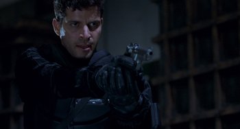 Movie still from “Resident Evil” (2002), directed by Paul W.S. Anderson – A man holding a gun while wearing a glove; Close Up shot, Low angle