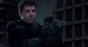Movie still from “Resident Evil” (2002), directed by Paul W.S. Anderson – A man in black jacket holding a gun in a dark room; Close Up shot, Low angle