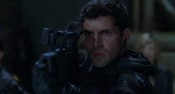 Movie still from “Resident Evil” (2002), directed by Paul W.S. Anderson – A man holding a gun while looking at the camera; Close Up shot, Over the shoulder angle