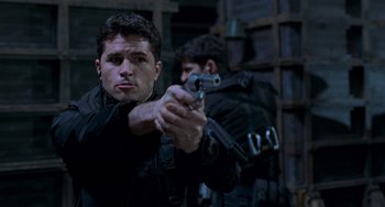 Movie still from “Resident Evil” (2002), directed by Paul W.S. Anderson – A man holding a gun while standing next to another man; Close Up shot, Low angle