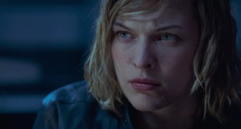 Movie still from “Resident Evil” (2002), directed by Paul W.S. Anderson – A woman's face in the dark; Close Up shot, Over the shoulder angle