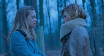 Movie still from “Resident Evil” (2002), directed by Paul W.S. Anderson – Two women standing next to each other on a bench; Medium shot, Over the shoulder angle