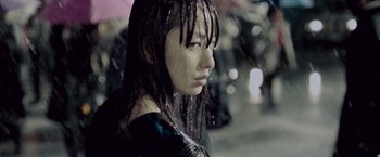 Movie still from “Resident Evil: Afterlife” (2010), directed by Paul W.S. Anderson – A young woman with long black hair standing in the pouring rain; Close Up shot, Low angle
