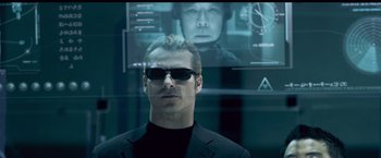 Movie still from “Resident Evil: Afterlife” (2010), directed by Paul W.S. Anderson – A man in a suit and sunglasses in front of a computer screen; Close Up shot, Low angle