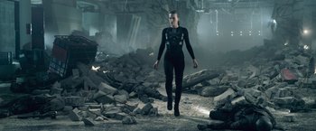 Movie still from “Resident Evil: Afterlife” (2010), directed by Paul W.S. Anderson – A woman in a body suit walking through rubble; Wide shot, Low angle