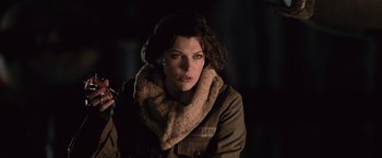 Movie still from “Resident Evil: Afterlife” (2010), directed by Paul W.S. Anderson – A woman wearing a brown jacket and a fur scarf; Medium shot, Low angle