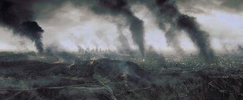 Movie still from “Resident Evil: Afterlife” (2010), directed by Paul W.S. Anderson – An aerial view of a city with smoke billowing out of it; Extreme Wide shot, High angle