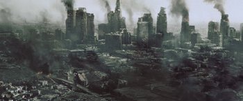 Movie still from “Resident Evil: Afterlife” (2010), directed by Paul W.S. Anderson – An aerial view of a city with smoke billowing out of the buildings; Extreme Wide shot, High angle