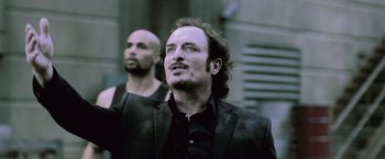 Movie still from “Resident Evil: Afterlife” (2010), directed by Paul W.S. Anderson – A man in a black jacket and a bald man in a black jacket; Close Up shot, Low angle