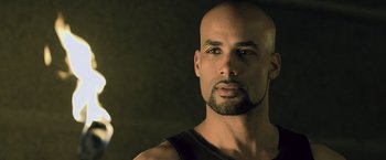 Movie still from “Resident Evil: Afterlife” (2010), directed by Paul W.S. Anderson – A man with a bald head is looking at the camera; Close Up shot, Over the shoulder angle