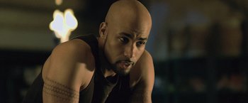 Movie still from “Resident Evil: Afterlife” (2010), directed by Paul W.S. Anderson – A man with a shaved bald head is looking at the camera; Close Up shot, Over the shoulder angle