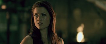 Movie still from “Resident Evil: Afterlife” (2010), directed by Paul W.S. Anderson – A beautiful woman with long brown hair looking at the camera; Close Up shot, Over the shoulder angle
